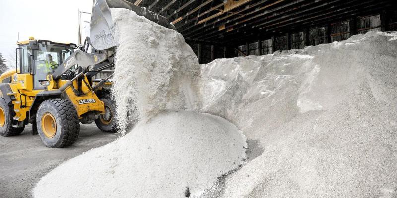 Front loader scooping winter road salt for maintenance work